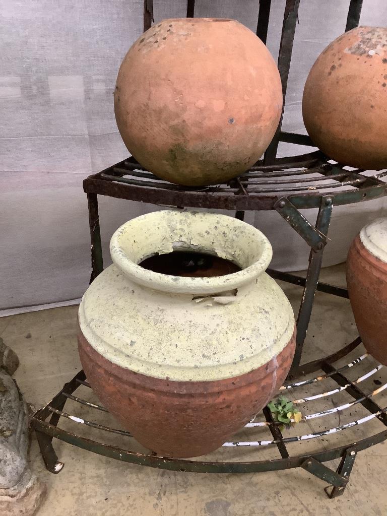 Five assorted terracotta pots together with a wrought iron corner pot stand, height 75cm